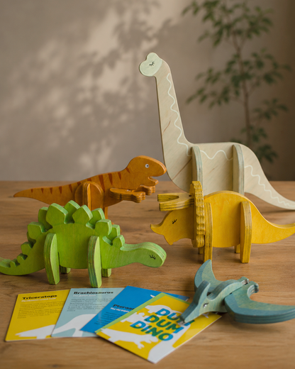 Set of colorful wooden dinosaur toys with information card