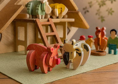 Playful wooden farm animals with a barn in the background. 