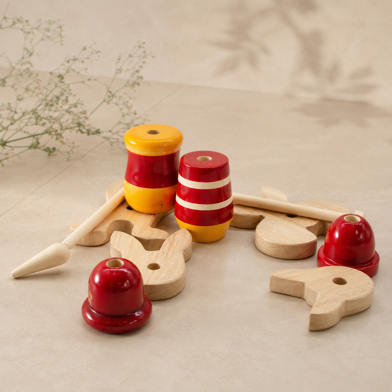 Wooden toys with red and yellow striped cylindrical pieces on a beige surface.